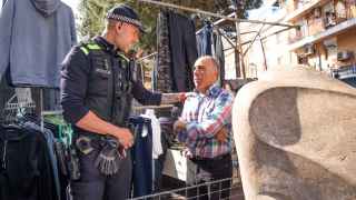 Uno de los agentes de la Policía Local de Santa Coloma con un paradista del mercadillo de Fondo