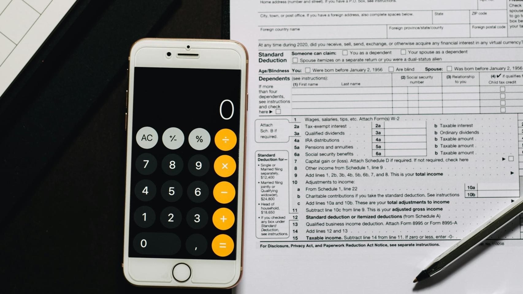 Móvil (en modo calculadora) y papeles