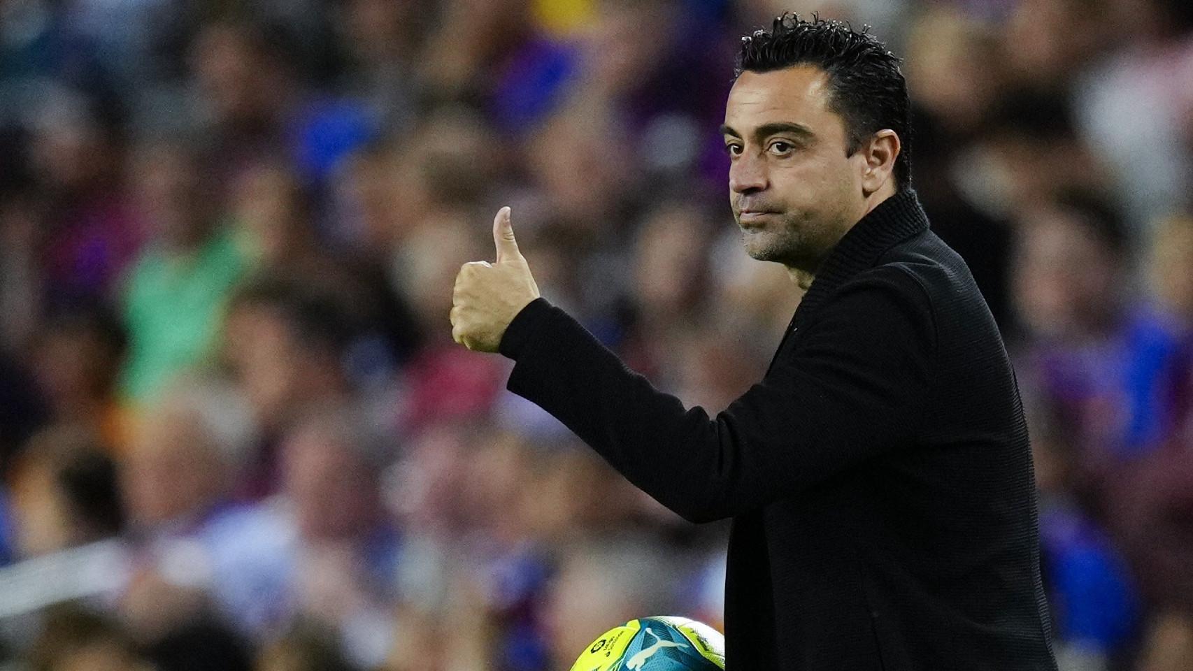 Xavi Hernández hace un gesto con la mano a un jugador del Barça