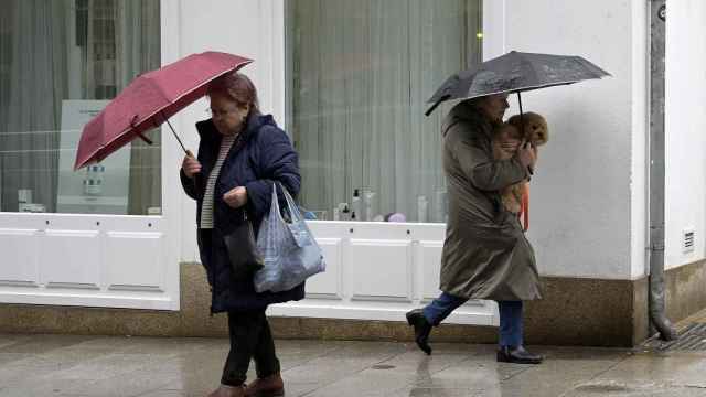 Dos mujeres se refugian de la lluvia en Barcelona