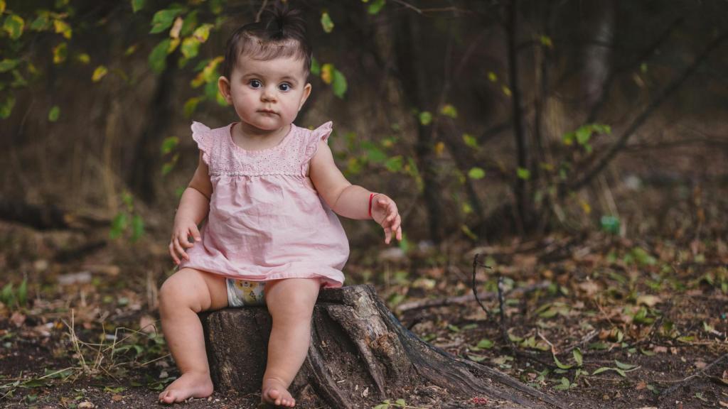 Una niña sentada en un tronco
