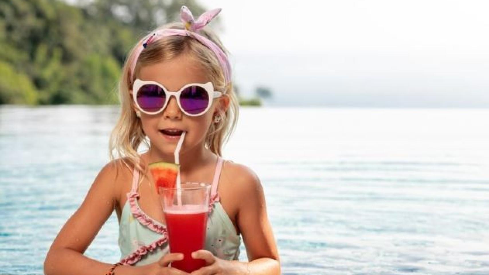 Niña en una piscina tomando algo