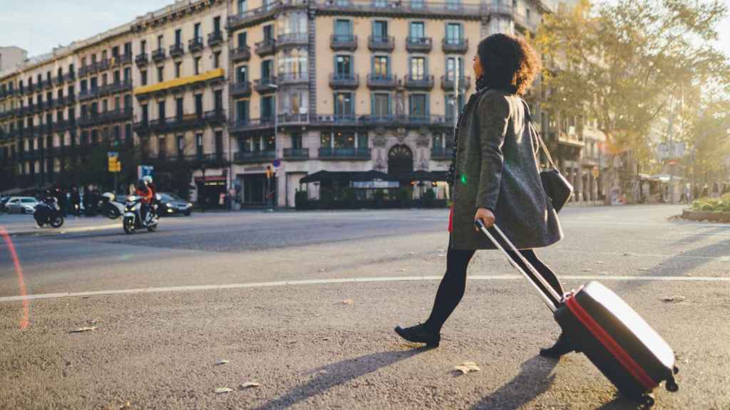 Una dona passeja amb una maleta a Barcelona