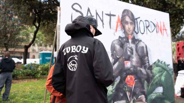 El artista urbano TVBoy, junto a su cartel