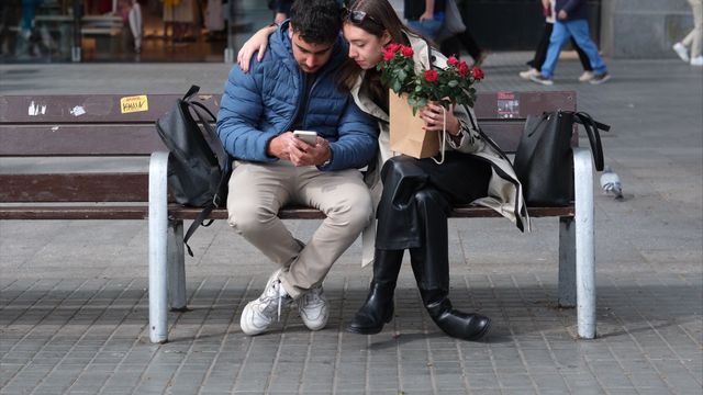 Una pareja en un banco durante la Diada de Sant Jordi