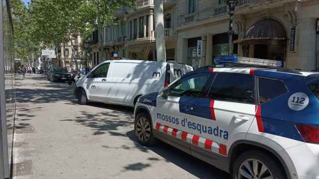 Un coche de los Mossos y otro de servicios funerarios delante del hotel
