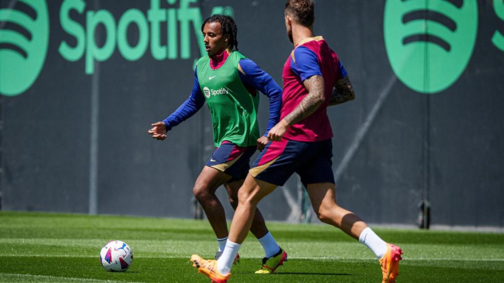 Jules Koundé conduce el balón en un entrenamiento del Barça, perseguido por Iñigo Martínez