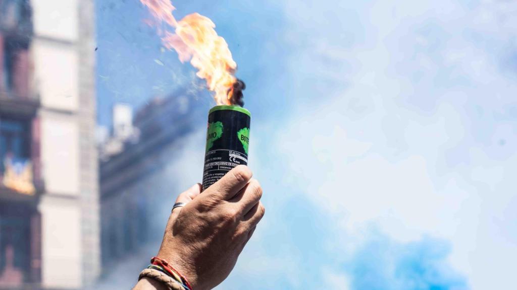 Un trabajador de prisiones sostiene una bengala de humo