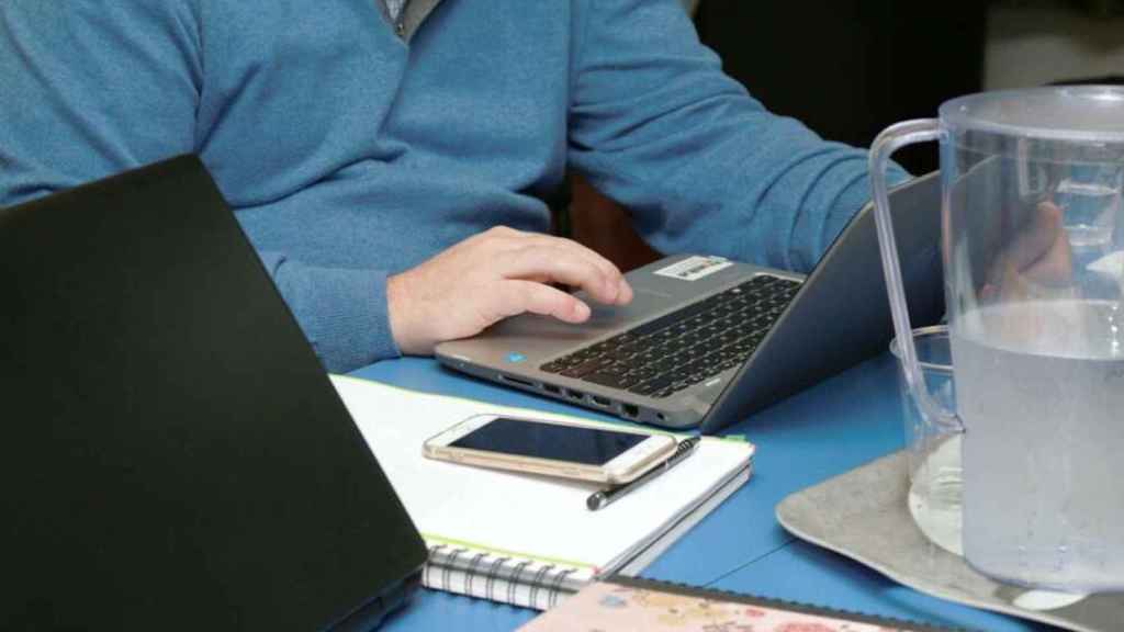 Un home accedeix a internet amb un portàtil