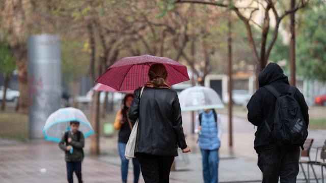 Varias presonas protegiéndose de la lluvia