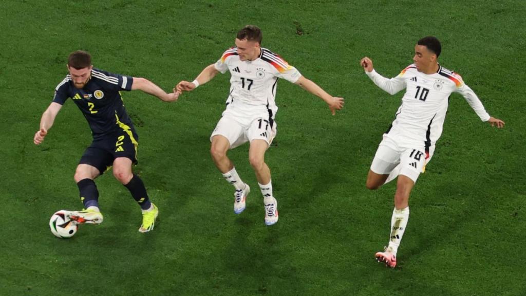 Florian Wirtz y Jamal Musiala persiguen a un futbolista de Escocia