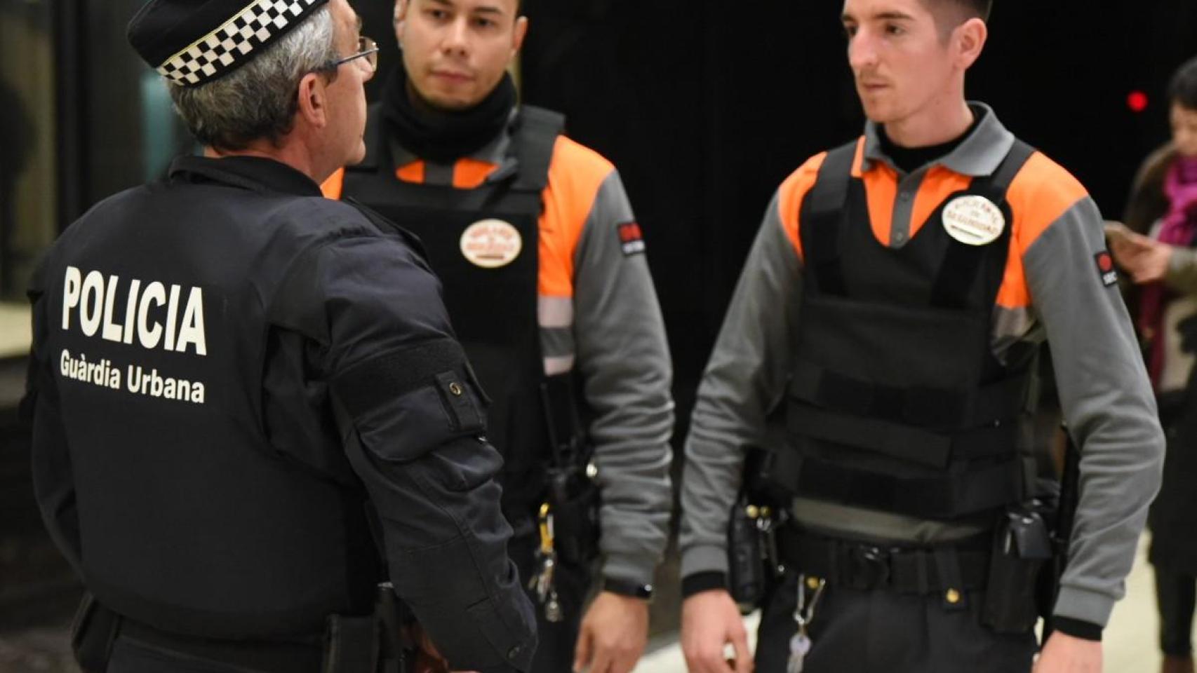 Vigilantes de seguridad junto a un agente de la Guardia Urbana en Barcelona