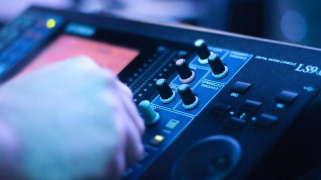 Imagen de un dj junto a una mesa de sonido