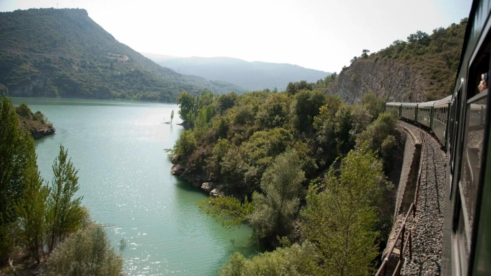 Un tren histórico pasando por un lago