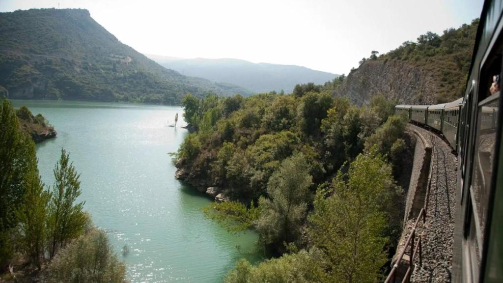 Un tren histórico pasando por un lago