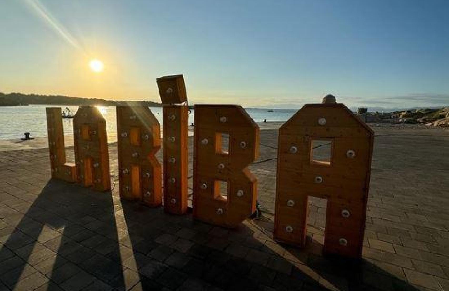 Letras de La Riba con el atardecer de fondo