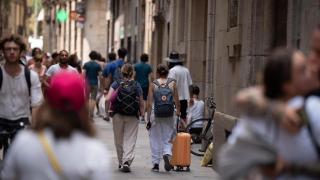 Varias personas pasean por Las Ramblas de Barcelona, entre ellas, turistas
