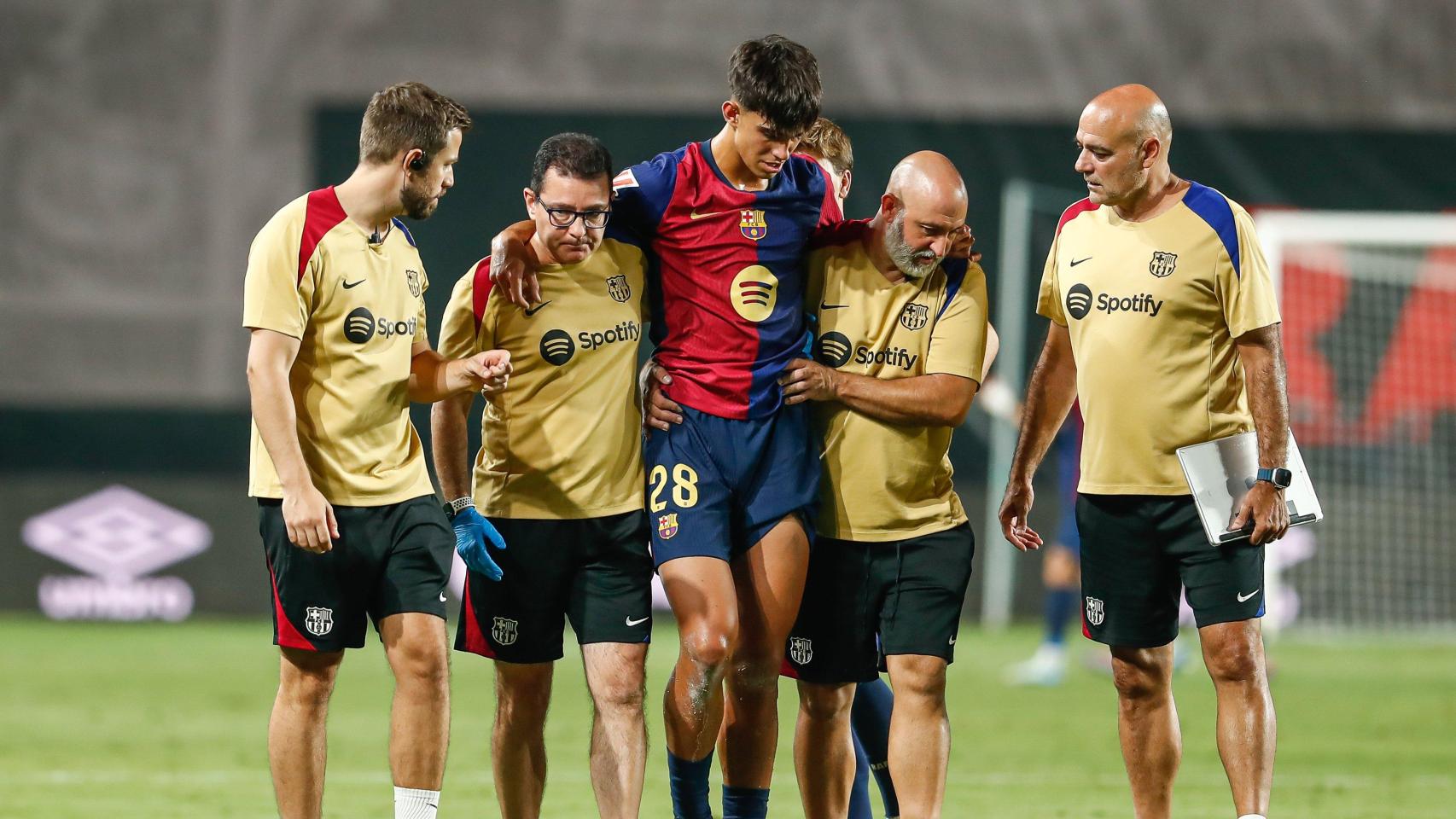 Marc Bernal se marcha lesionado de Vallecas, apoyado en el hombro del doctor Carles Miñarro (izquierda)