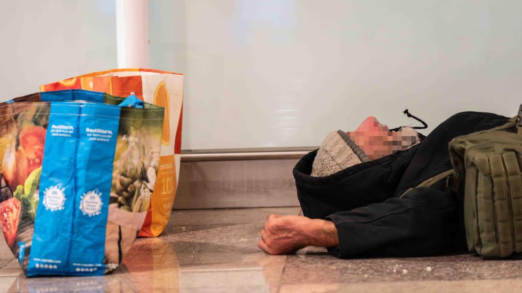 Una persona sin hogar durmiendo en el Aeropuerto de Barcelona