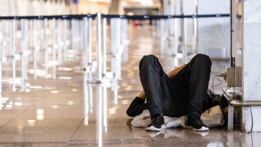 Una persona sense llar dormint a l'Aeroport de Barcelona