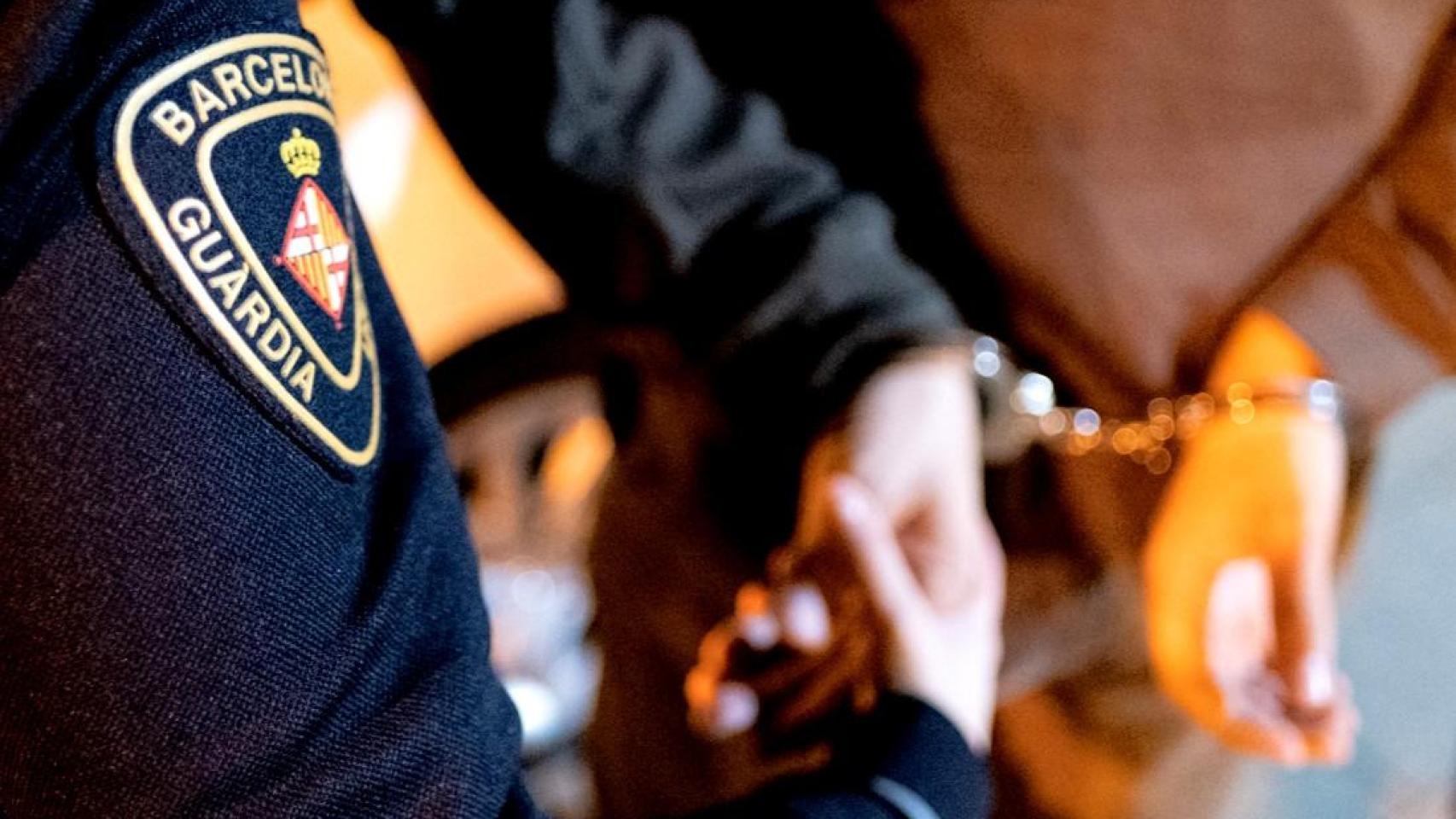 Un agente de la Guardia Urbana de Barcelona detiene a un hombre