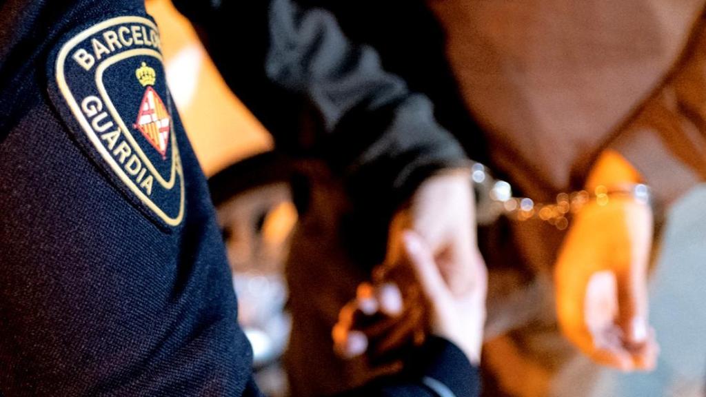 Un agente de la Guardia Urbana de Barcelona detiene a un hombre