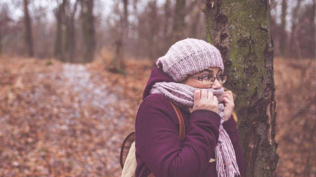 Una mujer en un bosque pasando frío