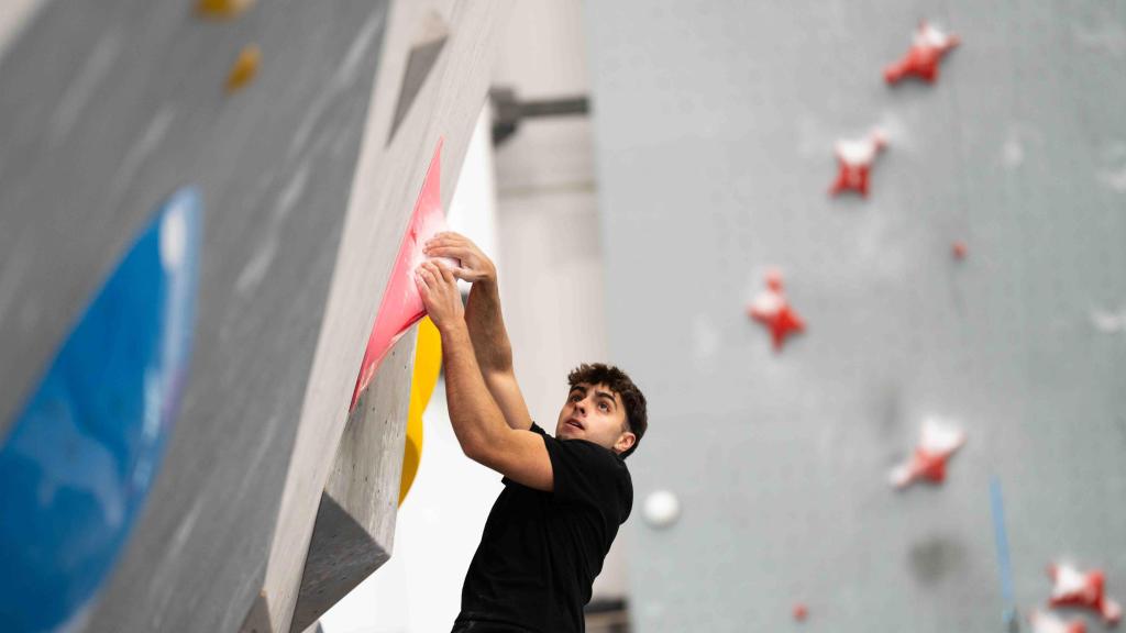 Jove escalant una paret de blocs en el Sharma Climbing de Gavà