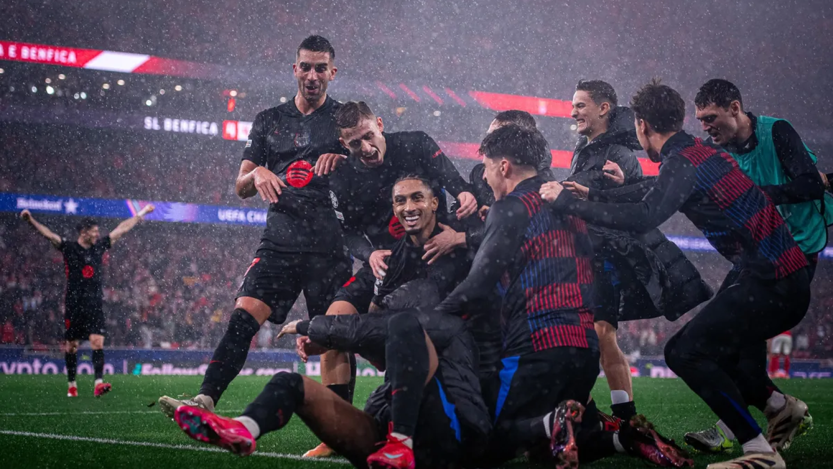 Raphinha celebra el quinto gol del Barça en Lisboa con todos sus compañeros arremolinados encima suyo