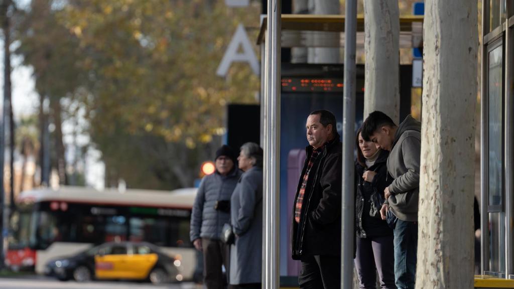 Varias personas esperan al autobús en Barcelona