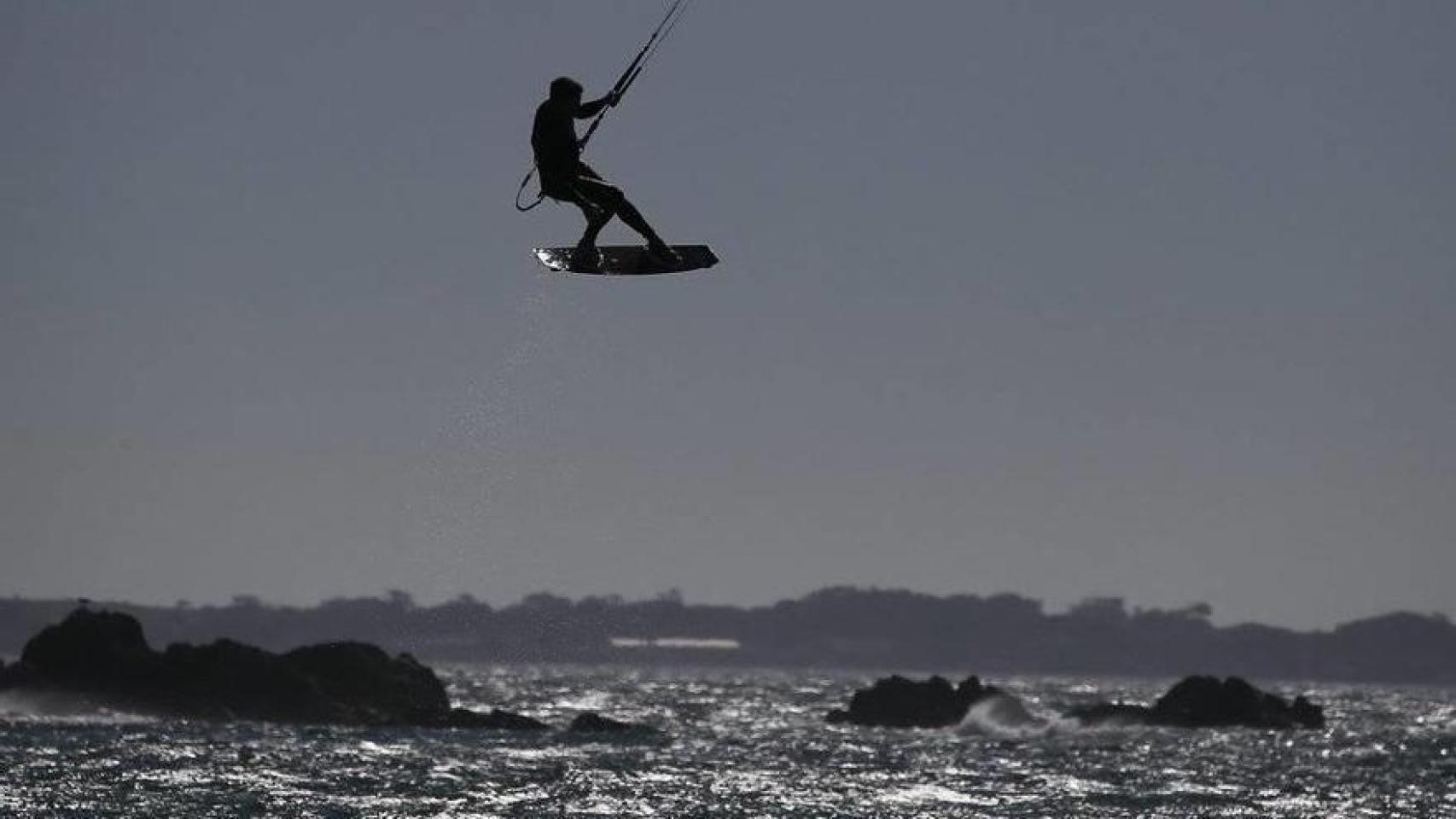 Un deportista practicando kitesurf en la costa de Barcelona