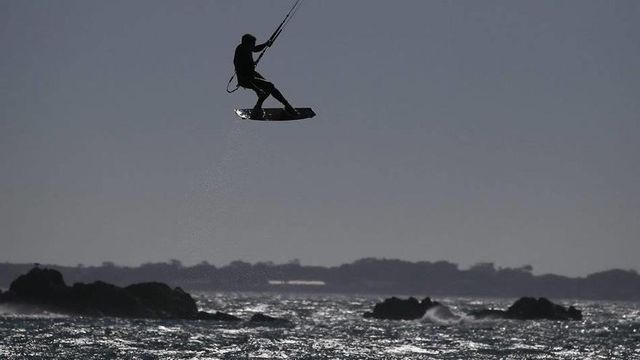 Un deportista practicando kitesurf en la costa de Barcelona
