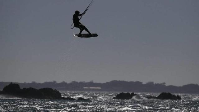 Un deportista practicando kitesurf en la costa de Barcelona