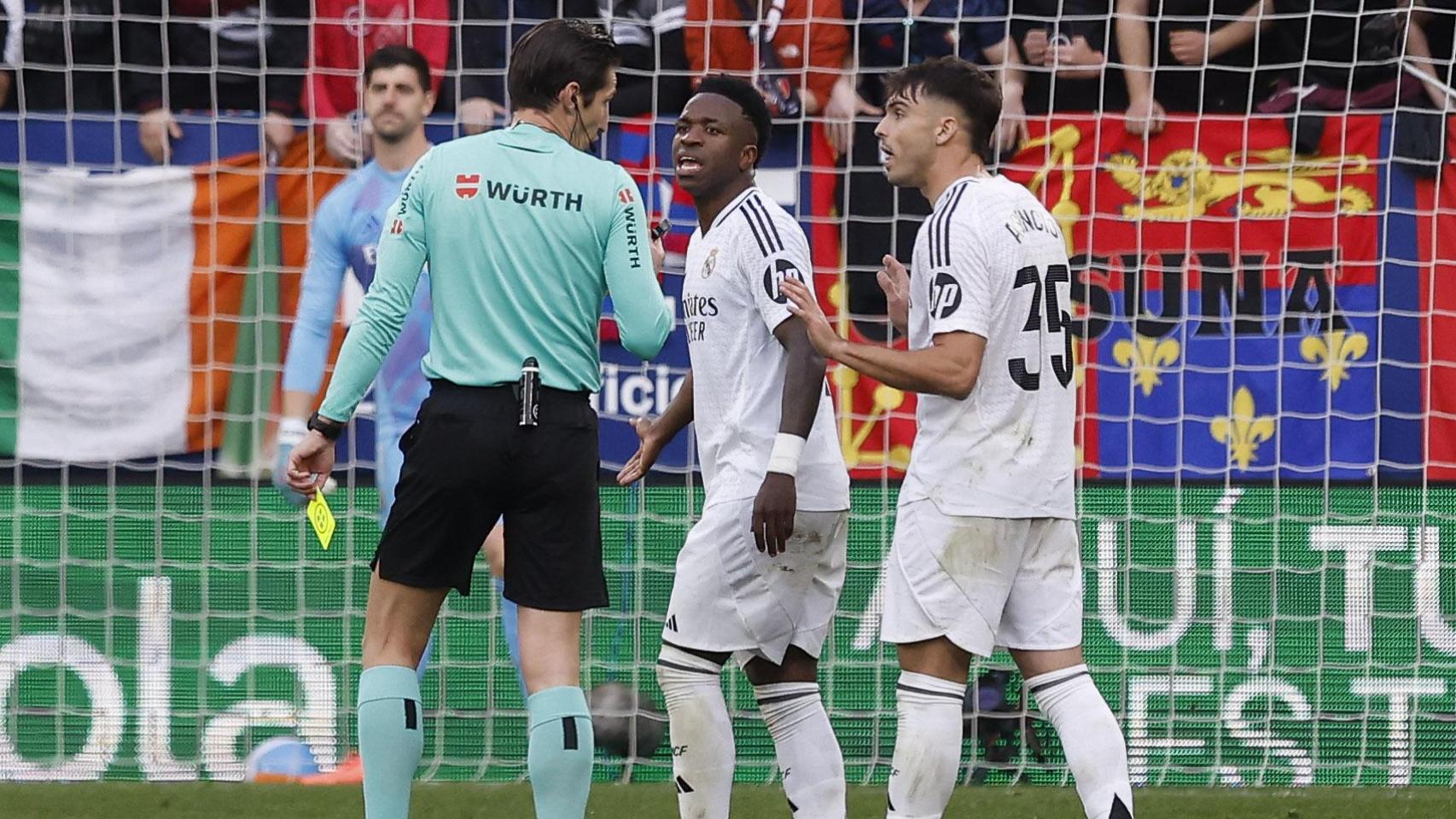 Vinicius Jr y Raúl Asencio protestan una decisión al árbitro Munuera Montero durante el Osasuna-Real Madrid
