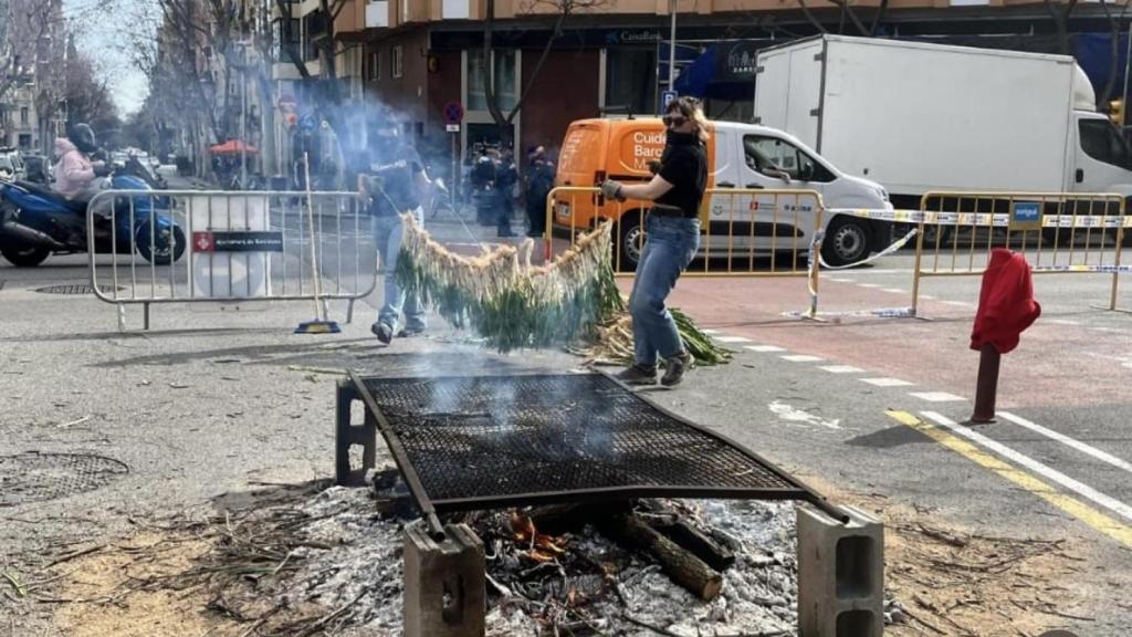 Parrilla en el suelo para asar calçots en la calle Sicília