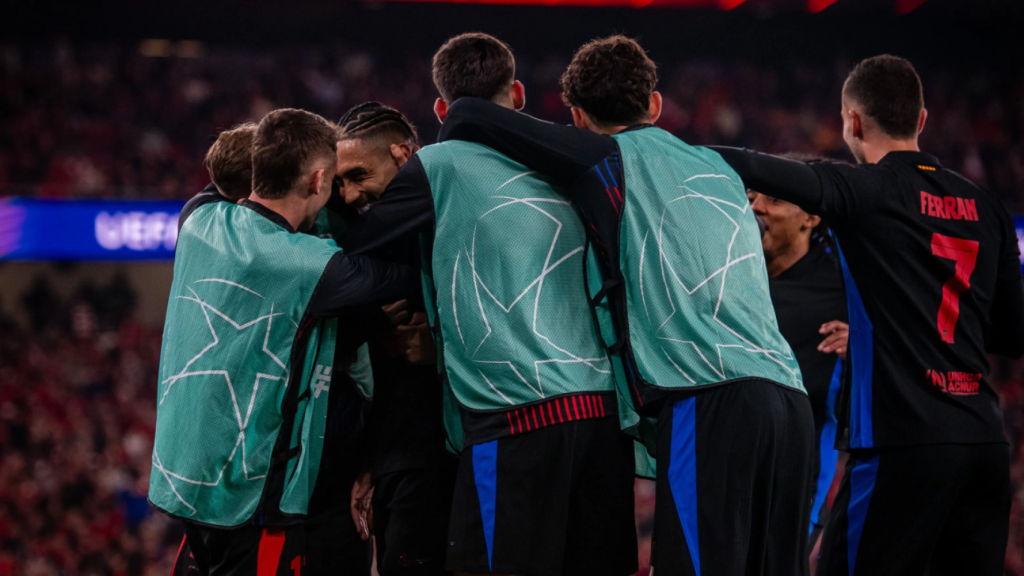 Los suplentes del Barça abrazan a Raphinha tras marcar el gol de la victoria contra el Benfica en la Champions League
