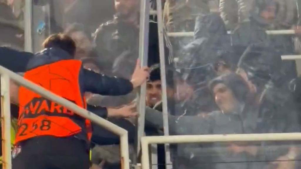 Un 'steward' del Barça lucha por contener a la afición del Lisboa en su sector de Montjuïc