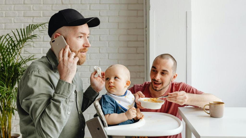Un padre trata de dar de comer a su hijo