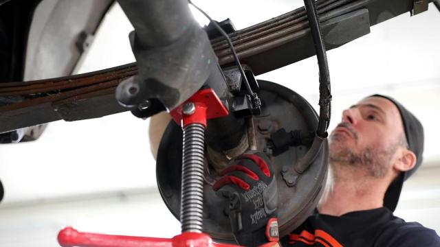 Un mecánico revisa el sistema de frenos de un vehículo