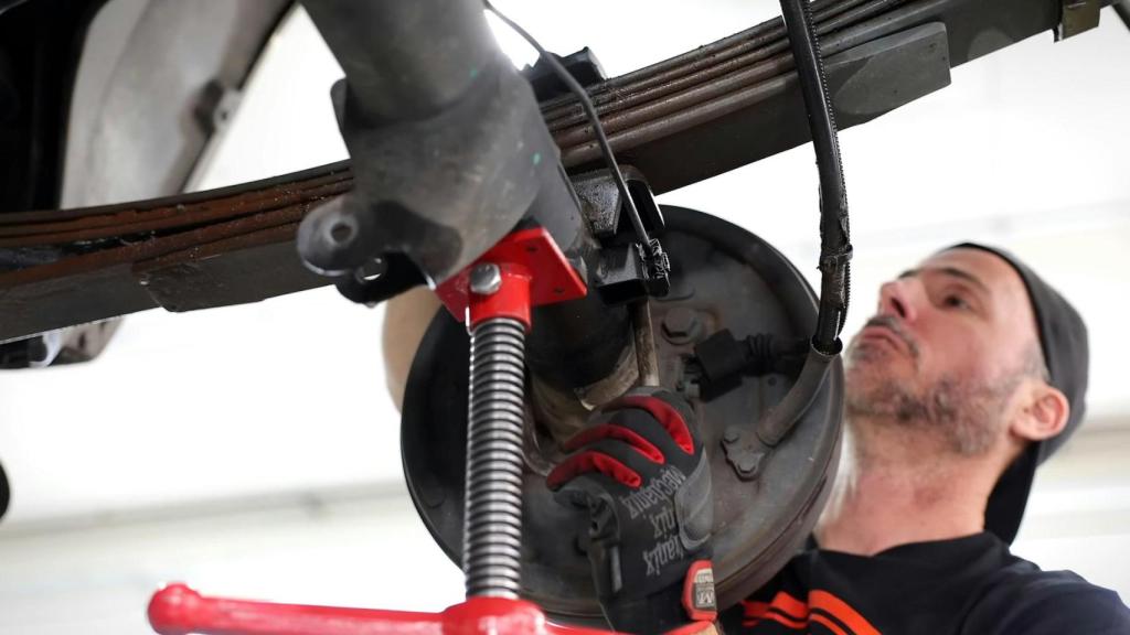 Un mecánico revisa el sistema de frenos de un vehículo