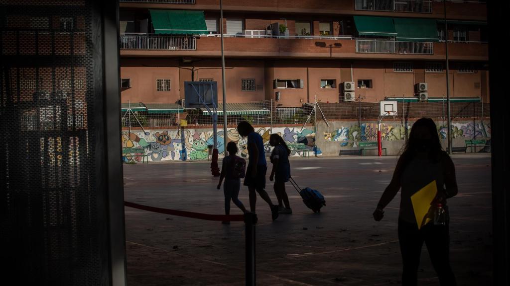Padres y alumnos en el patio de un colegio, en una imagen de archivo