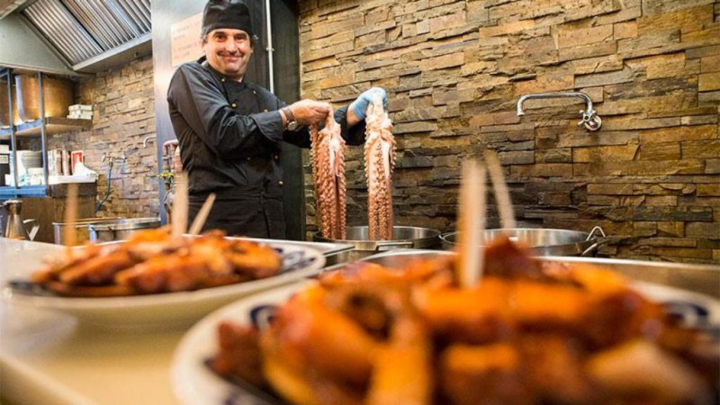 Un cocinero de la pulpería can Lampazas, con dos pulpos en la mano