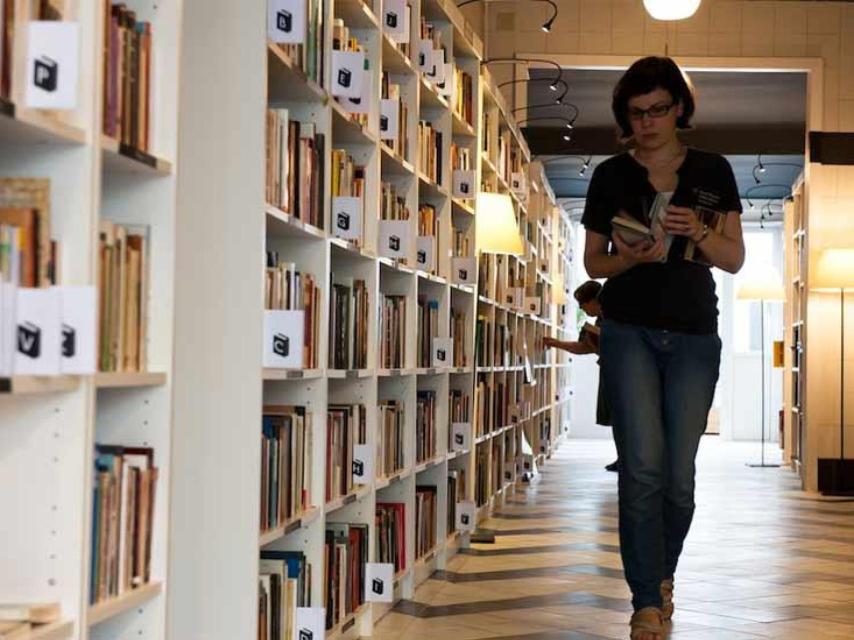 Una mujer hojea un libro dentro del local de Re-read en Mataró