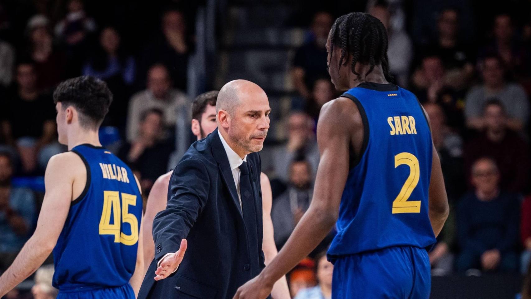 Joan Peñarroya le choca la mano a Dame Sarr en un partido del Barça de basket