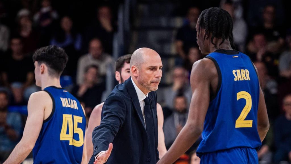 Joan Peñarroya le choca la mano a Dame Sarr en un partido del Barça de basket