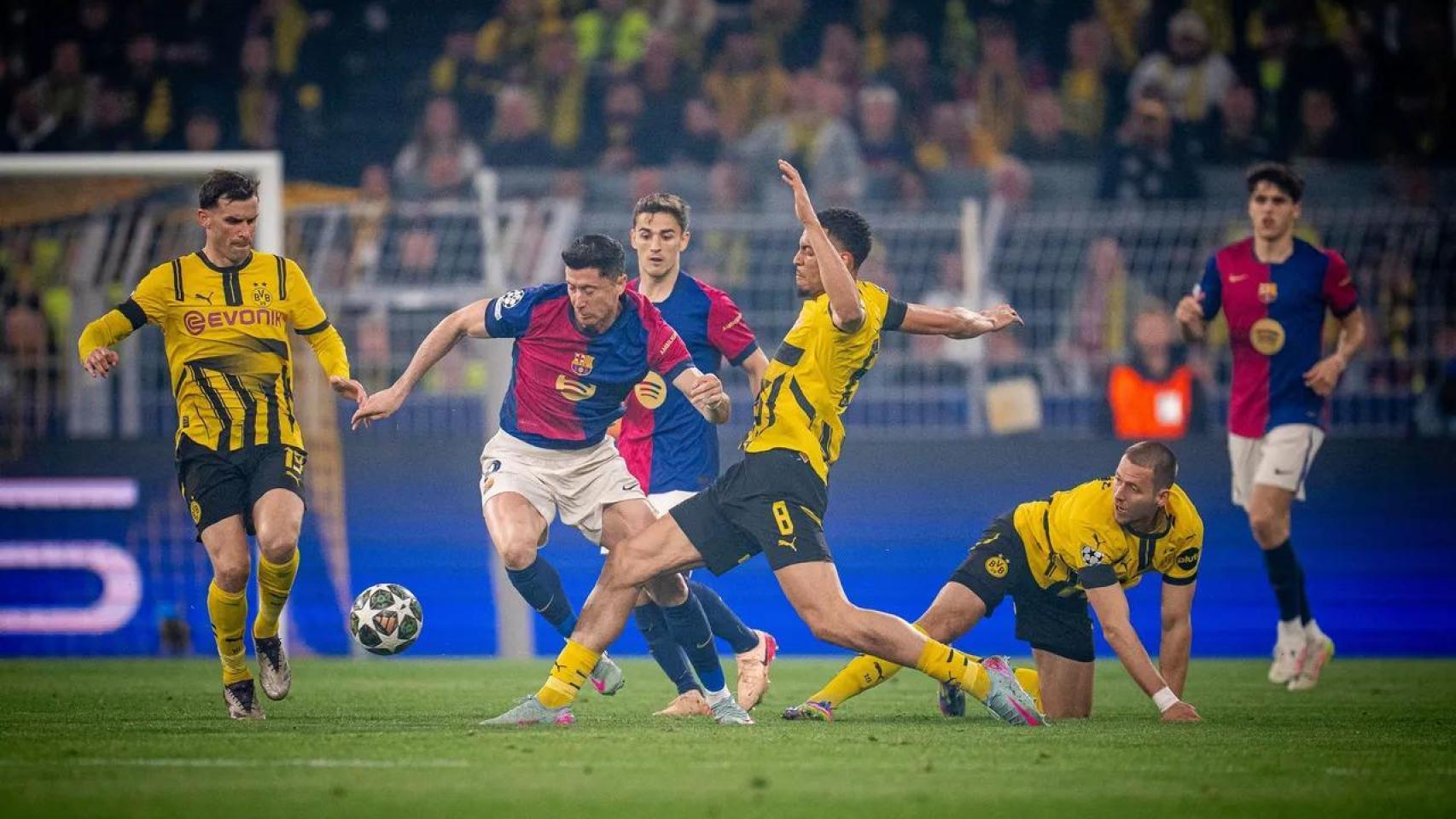 Robert Lewandowski lucha por llevarse un balón en el Borussia-Barça