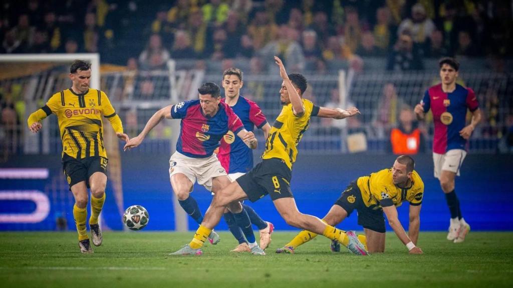 Robert Lewandowski lucha por llevarse un balón en el Borussia-Barça