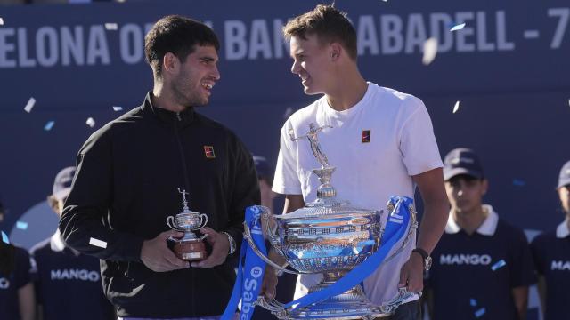 El tenista danés Holger Rune (d) con el trofeo tras su victoria ante el español Carlos Alcaraz (i) en la final del Barcelona Open Banc Sabadell-Trofeo Conde de Godó disputado este domingo en Barcelona
