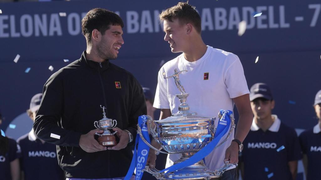 El tenista danés Holger Rune (d) con el trofeo tras su victoria ante el español Carlos Alcaraz (i) en la final del Barcelona Open Banc Sabadell-Trofeo Conde de Godó disputado este domingo en Barcelona