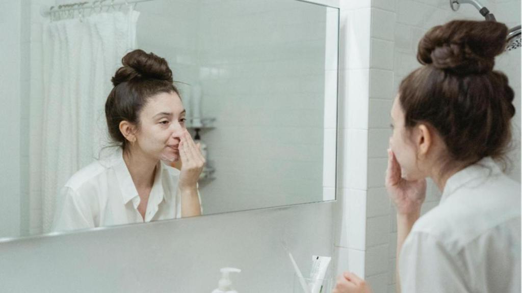 Una mujer se aplica crema facial